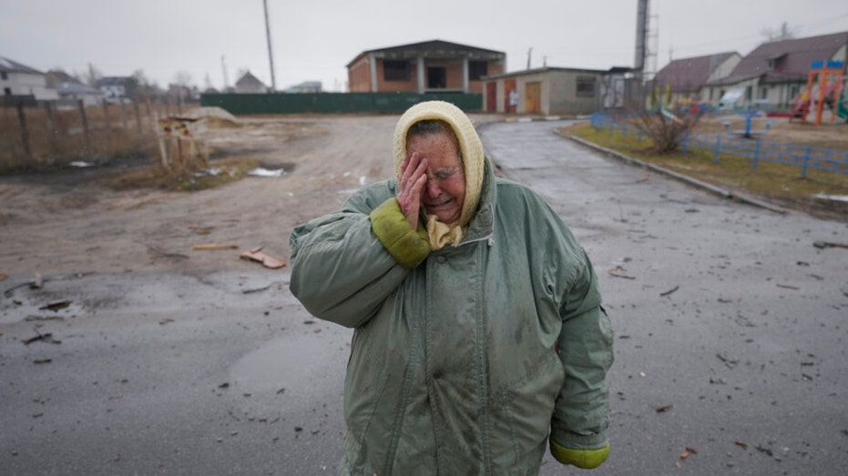 A woman cries outside houses damaged by a Russian airstrike