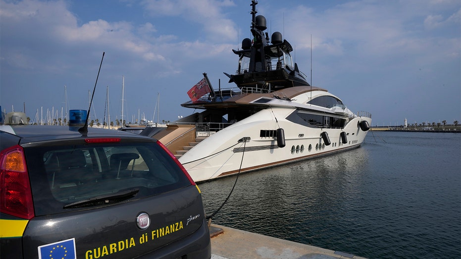 An Italian Finance Police car is parked in front of the yacht "Lady M", owned by Russian oligarch Alexei Mordashov, docked at Imperia's harbor, Italy, Saturday, March 5, 2022. (AP Photo/Antonio Calanni)