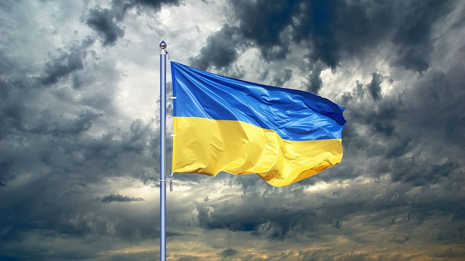 Ukrainian flag on black storm cloud sky. stormy weather