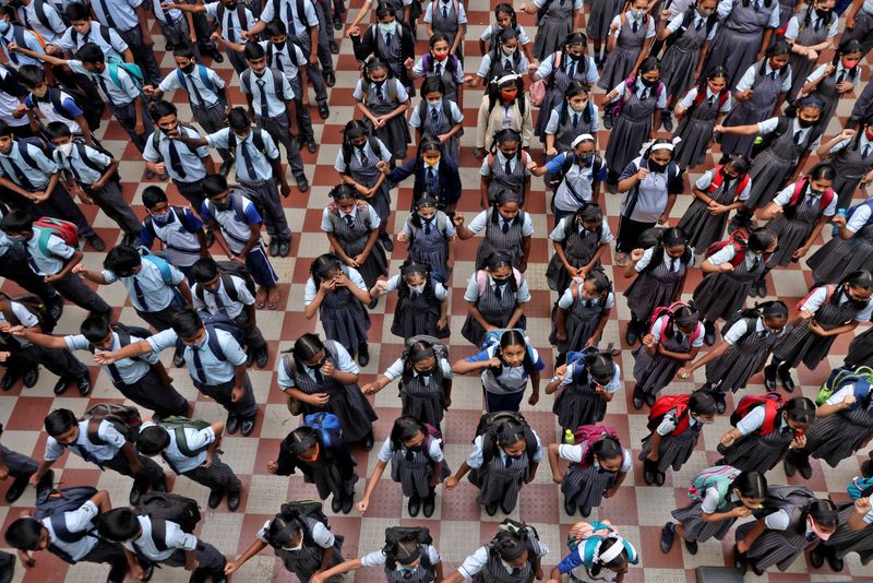 Schoolchildren assemble for morning prayers after schools in the western state of Maharashtra reopen with full capacity following their closure due to the coronavirus disease (COVID-19) pandemic, in Mumbai, India