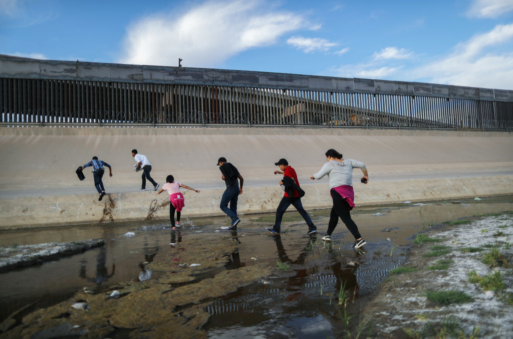 CIUDAD JUAREZ, MEXICO - MAY 19: Migrants cross the border between the U.S. and Mexico at the Rio Grande river, as they enter El Paso, Texas, on May 19, 2019 as taken from Ciudad Juarez, Mexico. The location is in an area where migrants frequently turn themselves in and ask for asylum in the U.S. after crossing the border. Approximately 1,000 migrants per day are being released by authorities in the El Paso sector of the U.S.-Mexico border amidst a surge in asylum seekers arriving at the Southern border. (Photo by Mario Tama/Getty Images)