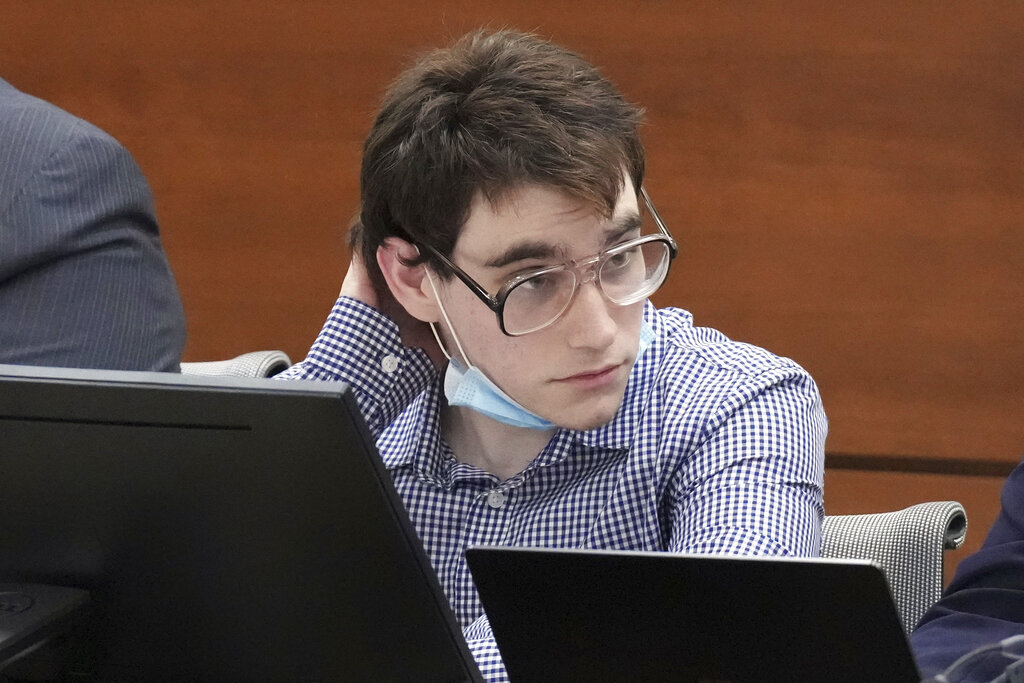 Nikolas Cruz, with his face mask pulled down, sits at the defense table during the third day of preliminary jury screening in the penalty phase of his trial, Wednesday, April 6, 2022, at the Broward County Courthouse in Fort Lauderdale, Fla. Cruz previously plead guilty to the 2018 murders of 17 people at Marjory Stoneman Douglas High School in Parkland, Fla. (Amy Beth Bennett/South Florida Sun-Sentinel via AP, Pool)