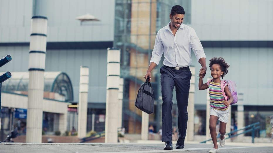 A father and daughter walk hand-in-hand