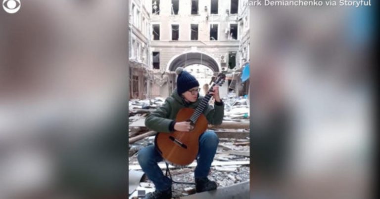 Young guitarist performs in ruins of Ukrainian city