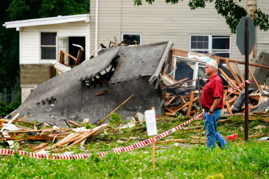 A person view the aftermath of a deadly explosion in a residential neighborhood in Pottstown, Pa., Friday, May 27, 2022. A house exploded northwest of Philadelphia, killing several people and leaving others injured, authorities said Friday. (AP Photo/Matt Rourke)