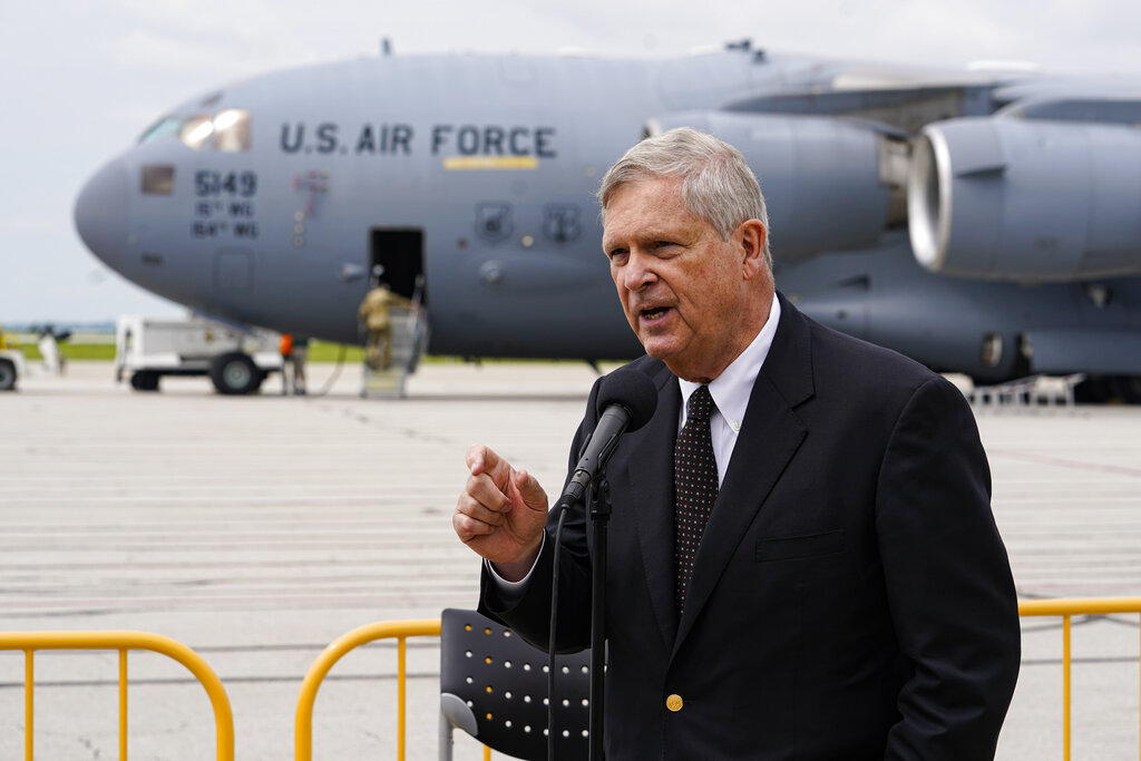 Agriculture Secretary Tom Vilsack, left, speaks after an Air Force C-17 delivered a plane load of baby formula at the Indianapolis International Airport in Indianapolis, Sunday, May 22, 2022. The 132 pallets of Nestlé Health Science Alfamino Infant and Alfamino Junior formula arrived from Ramstein Air Base in Germany. (AP Photo/Michael Conroy)