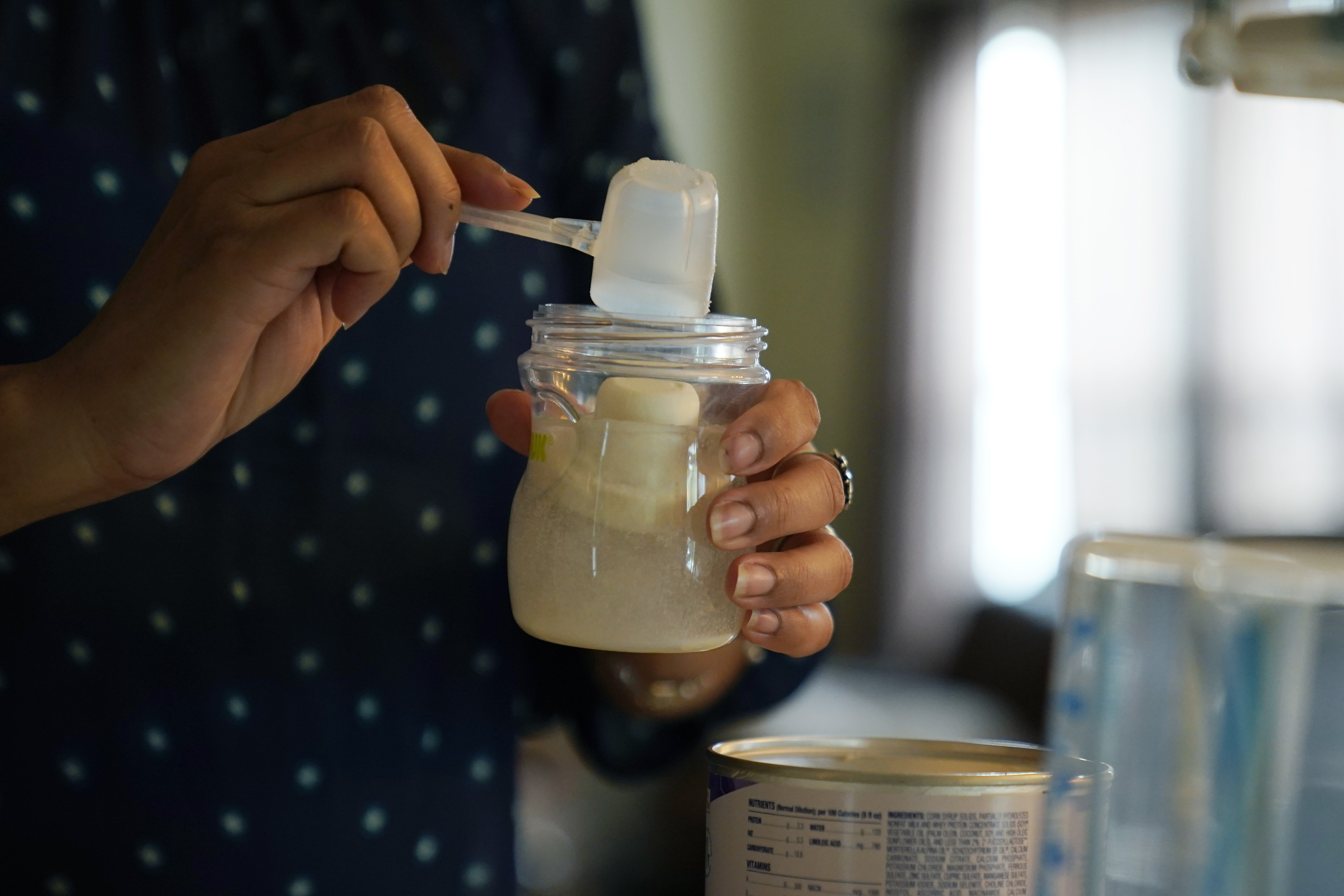 Olivia Godden prepares a bottle of baby formula for her infant son, Jaiden, Friday, May 13, 2022, at her home in San Antonio. Godden has reached out to family and friends as well as other moms through social media in efforts to locate needed baby formula which is in short supply. (AP Photo/Eric Gay)