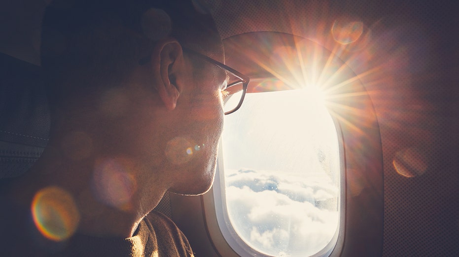 Man looks out airplane window
