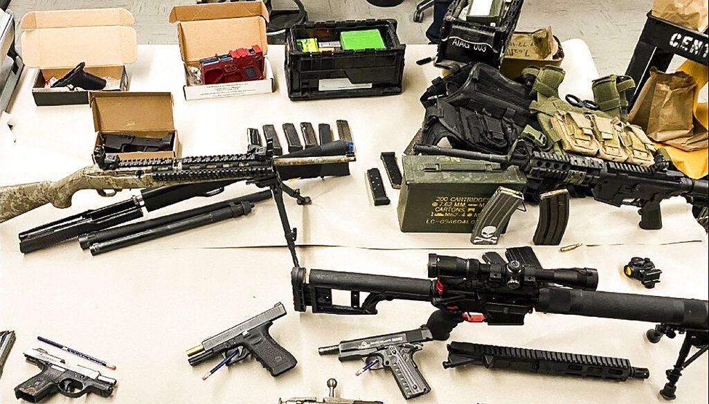This undated photo provided by the San Jose Police Department shows an arsenal of guns seized from suspect Bryan Velasquez, of San Jose, Calif. Velasquez, a disgruntled ex-worker, was charged with cyberstalking co-workers and police seized his arsenal of weapons. (Courtesy of San Jose Police Department via AP)