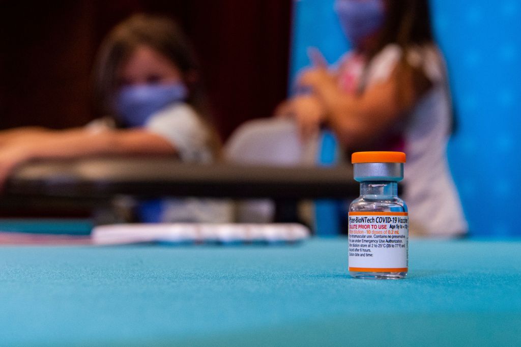A vial of the new children's dose of the Pfizer-BioNTech Covid-19 vaccine (that will supply ten doses, once reconstituted) sits in the foreground as children play in a hospital room waiting to be able to receive the vaccine at Hartford Hospital in Hartford, Connecticut on November 2, 2021. - An expert panel unanimously recommended Pfizer-BioNTech's Covid vaccine for five- to 11-year-olds on November 2, the penultimate step in the process that will allow injections in young children to begin this week in the United States. The Centers for Disease Control and Prevention (CDC), the top US public health agency, was expected to endorse that recommendation later in the day. (Photo by JOSEPH PREZIOSO / AFP) (Photo by JOSEPH PREZIOSO/AFP via Getty Images)