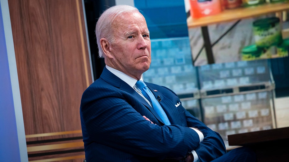 Joe Biden crosses his arms and frowns at a White House press conference