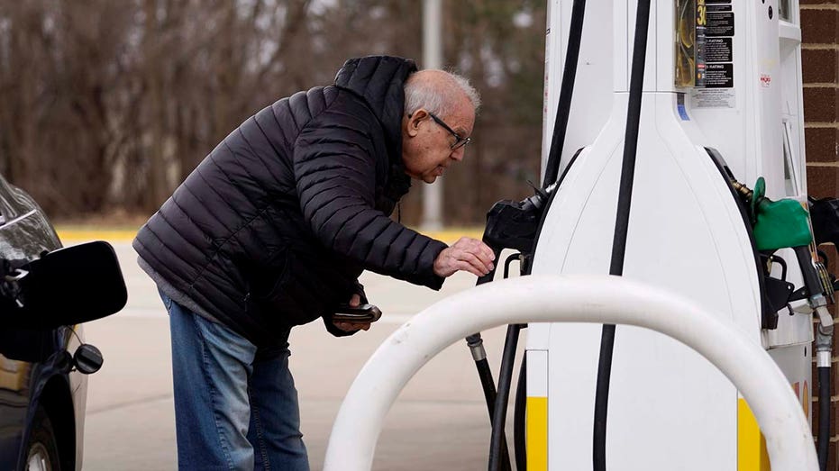 A man fill his gas tank. 