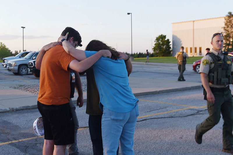 People pray at the CrossRoad Baptist Church parking lot after a shooting at Cornerstone Church in Ames, Iowa, U.S. June 2, 2022. Nirmalendu Majumdar/USA Today Network via REUTERS
