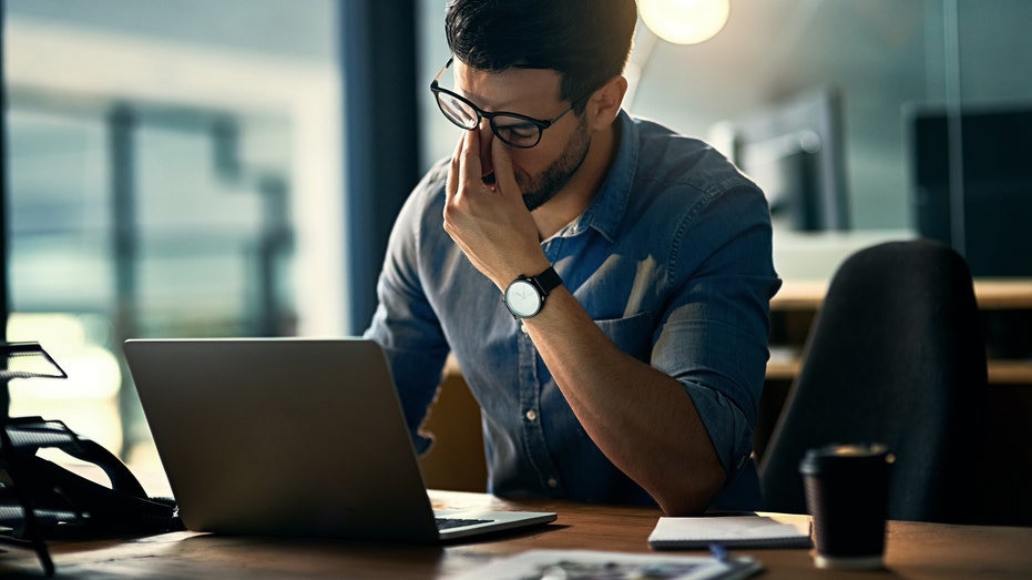 Stressed man pinches nose