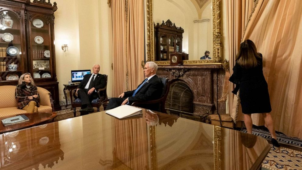 PHOTO: Vice President Mike Pence sits with his daughter and brother while wife Karen draws the curtains in ceremonial room off Senate floor where he was evacuated to as Trump supporters attacked U.S. Capitol, Jan. 6, 2021,