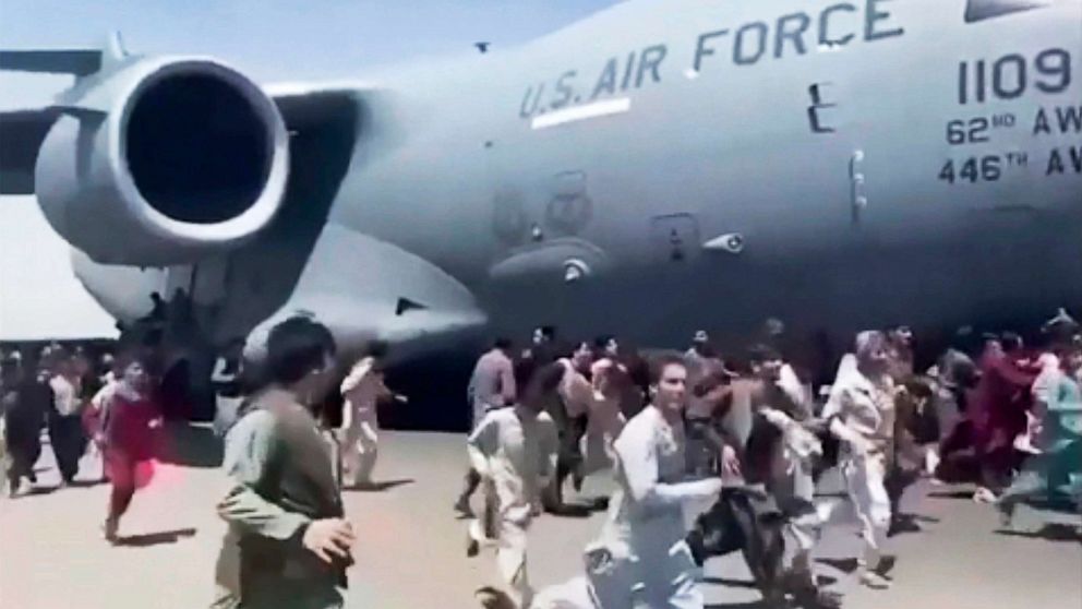 PHOTO: Some hundreds of people run alongside a U.S. Air Force C-17 transport plane as it moves down a runway of the international airport, in Kabul, Afghanistan, Aug. 16. 2021. 