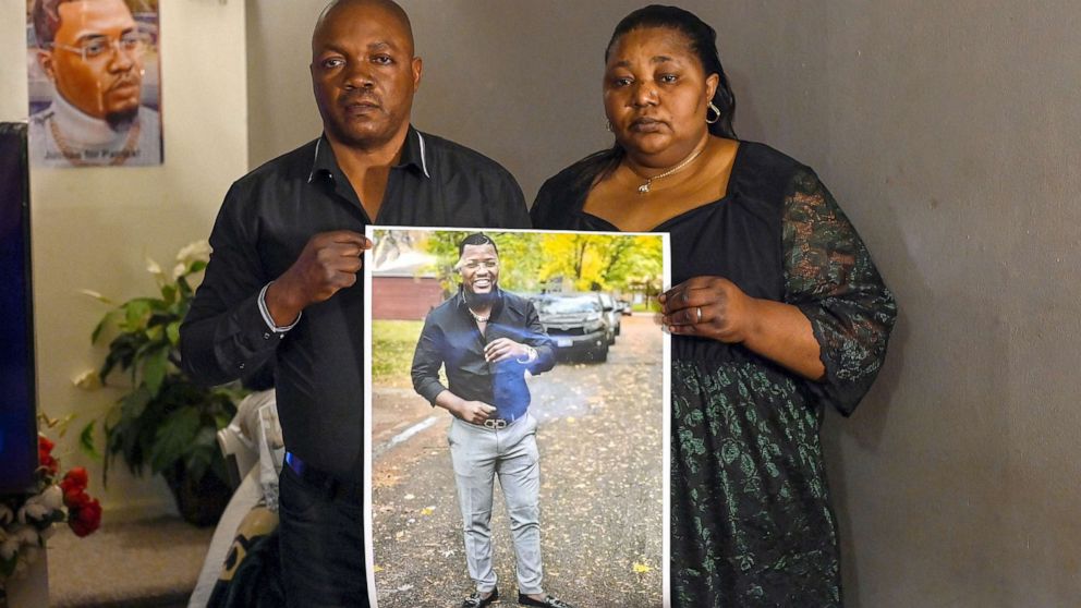 PHOTO: Patrick Lyoyas parents Peter Lyoya (L) and Dorcas Lyoya pose for a portrait as they hold a photo of their son at their home in Lansing, Mich., April 15, 2022. 