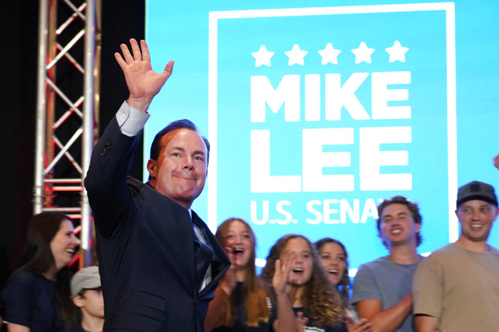 Sen. Mike Lee, R-Utah, walks out with his family in the background to declare victory to supporters during a Utah Republican primary-night party Tuesday, June 28, 2022, in South Jordan, Utah. Lee defeated two challengers in the primary. (AP Photo/George Frey)