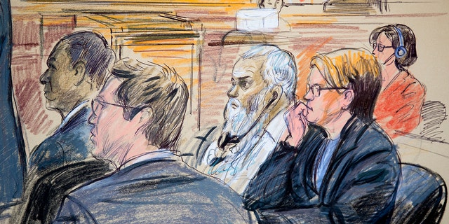 This courtroom sketch shows Ahmed Abu Khattalah, third from right, listening to an interpreter through earphones during the opening statement by his defense attorney Jeffery Robinson in federal court in Washington Monday, Oct. 2, 2017. 