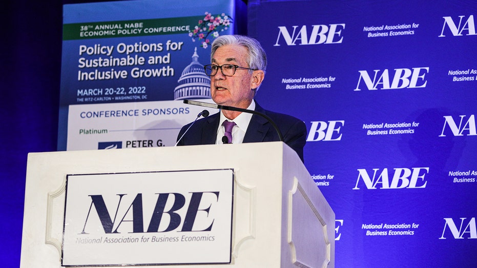 Jerome Powell speaking behind a podium at a NABE conference
