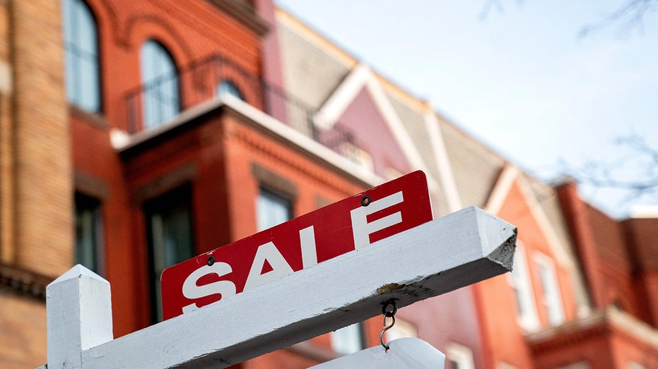 for sale sign in front of building