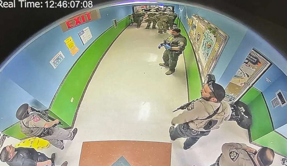 PHOTO: In this image first obtained by The New York Times, officers gather in the hallway of Robb Elementary School in Uvalde, Texas, May 24, 2022. The timestamp of 12:46 is visible in the image.