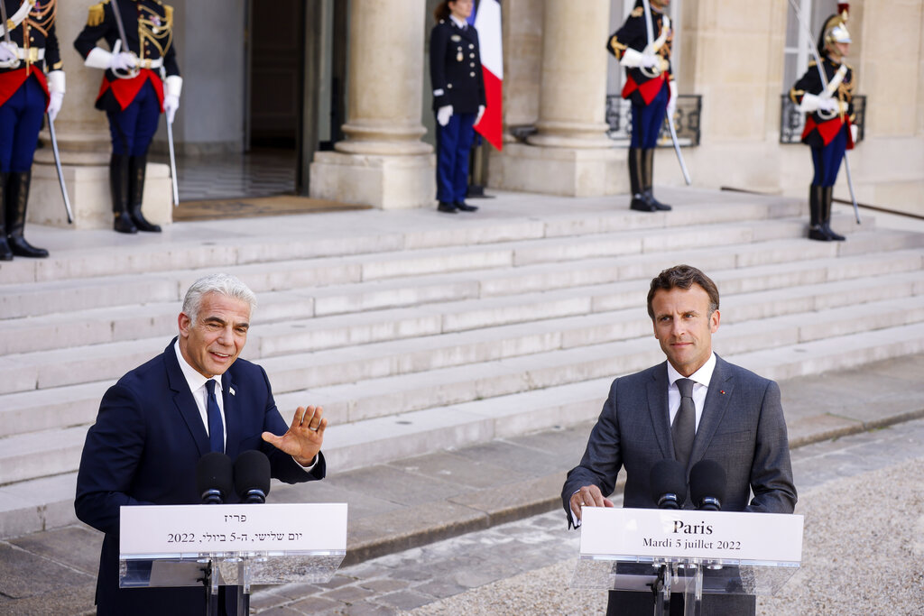 French President Emmanuel Macron, right, and Israel's Prime Minister Yair Lapid address journalists Tuesday, July 5, 2022 at the Elysee Palace in Paris. It was the first overseas trip by Yair Lapid since he took office last week. (AP Photo/Thomas Padilla)