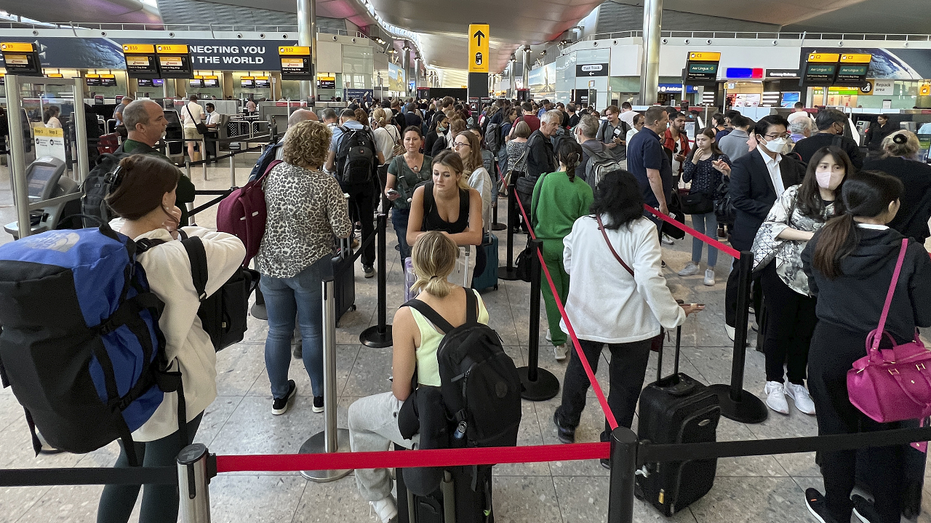 Passengers at Heathrow Airport line up