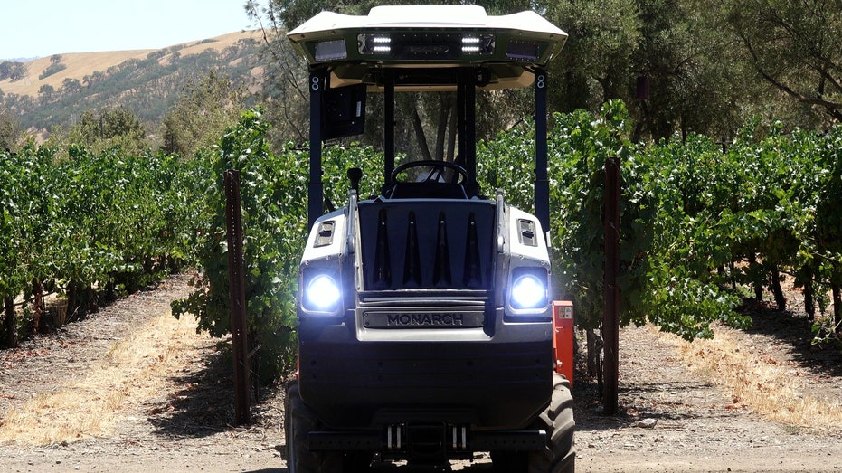 A self-driving tractor plows through a vineyard near Central California.