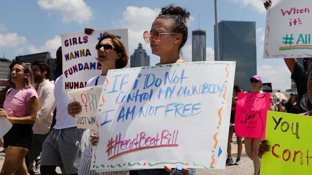 PHOTO: Demonstrators hold signs while marching during a protest against Georgia's 'heartbeat' abortion bill in Atlanta, Georgia, May 25, 2019. The bill bans abortion after a doctor can detect a fetal heartbeat, usually around the sixth week of pregnancy.