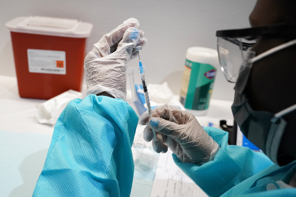 FILE - In this July 22, 2021, file photo, health care worker fills a syringe with the Pfizer COVID-19 vaccine at the American Museum of Natural History in New York. U.S. health officials Wednesday, Aug. 18, recommended all Americans get COVID-19 booster shots to shore up their protection amid the surging delta variant and evidence that the vaccines' effectiveness is falling. (AP Photo/Mary Altaffer, File)