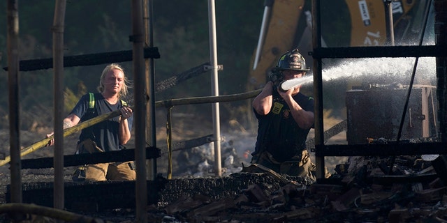 Firefighters put out hot spots on a home in Balch Springs, Texas, July 25, 2022.