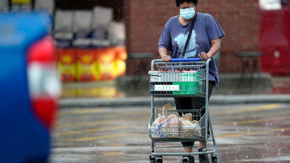 A shopper exits a Walmart store with items