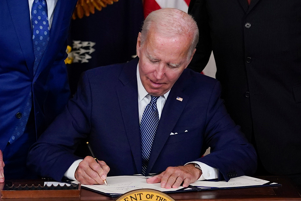 President Joe Biden signs the Democrats’ landmark climate change and health care bill in the State Dining Room of the White House in Washington, Tuesday, Aug. 16, 2022. (AP Photo/Susan Walsh)