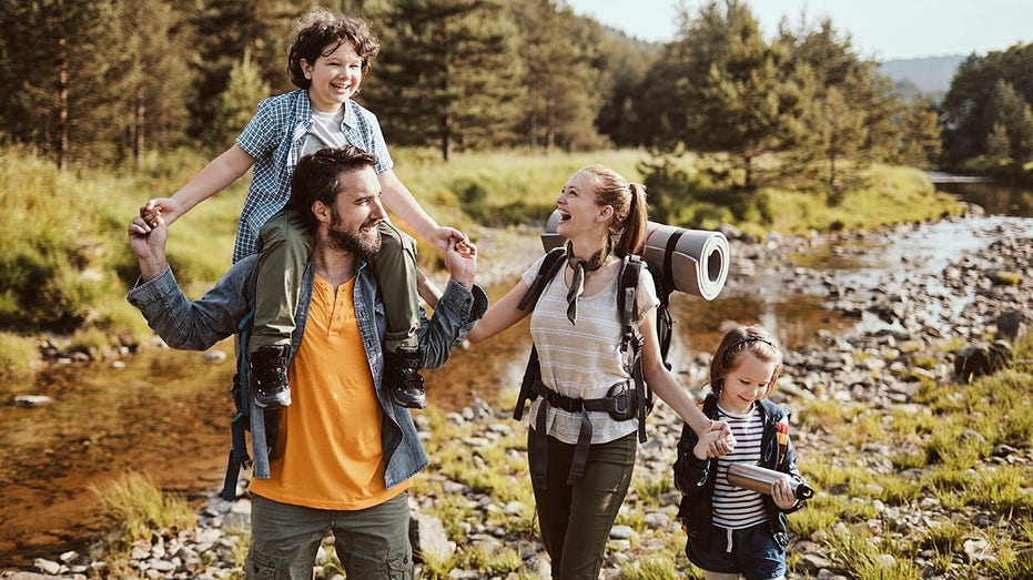 family hikes together in woods