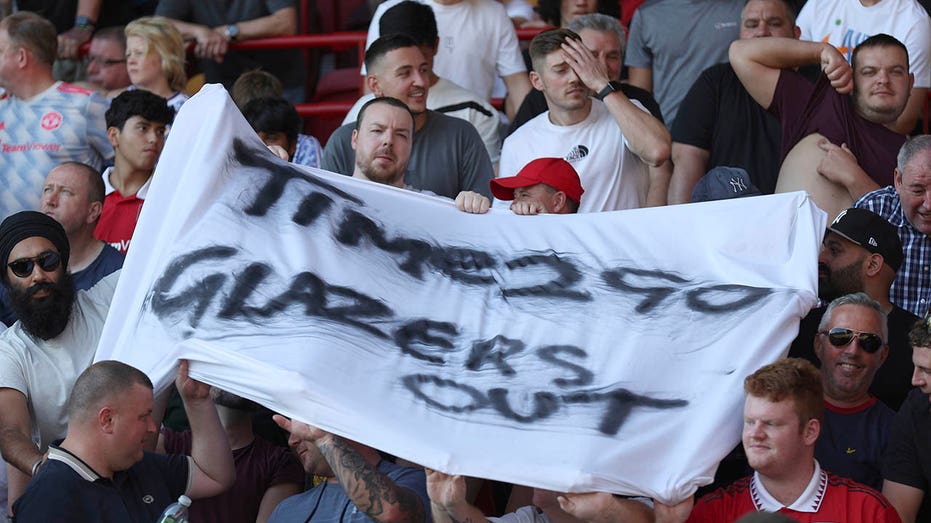 Manchester United fans hold up a banner