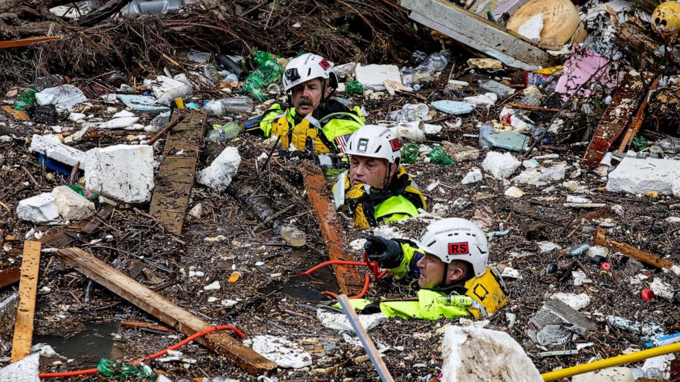 PHOTO: Members of the Tennessee Task Force One search and rescue team wade through the debris-filled Troublesome Creek, after a search dog detected the scent of a potential victim in Perry County, Kentucky, on July 31, 2022.