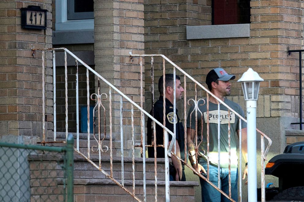 PHOTO: A New Jersey police officer and a plain-clothed police officer exit the building where alleged attacker of Salman Rushdie, Hadi Matar, lives in Fairview, N.J., Aug. 12, 2022.