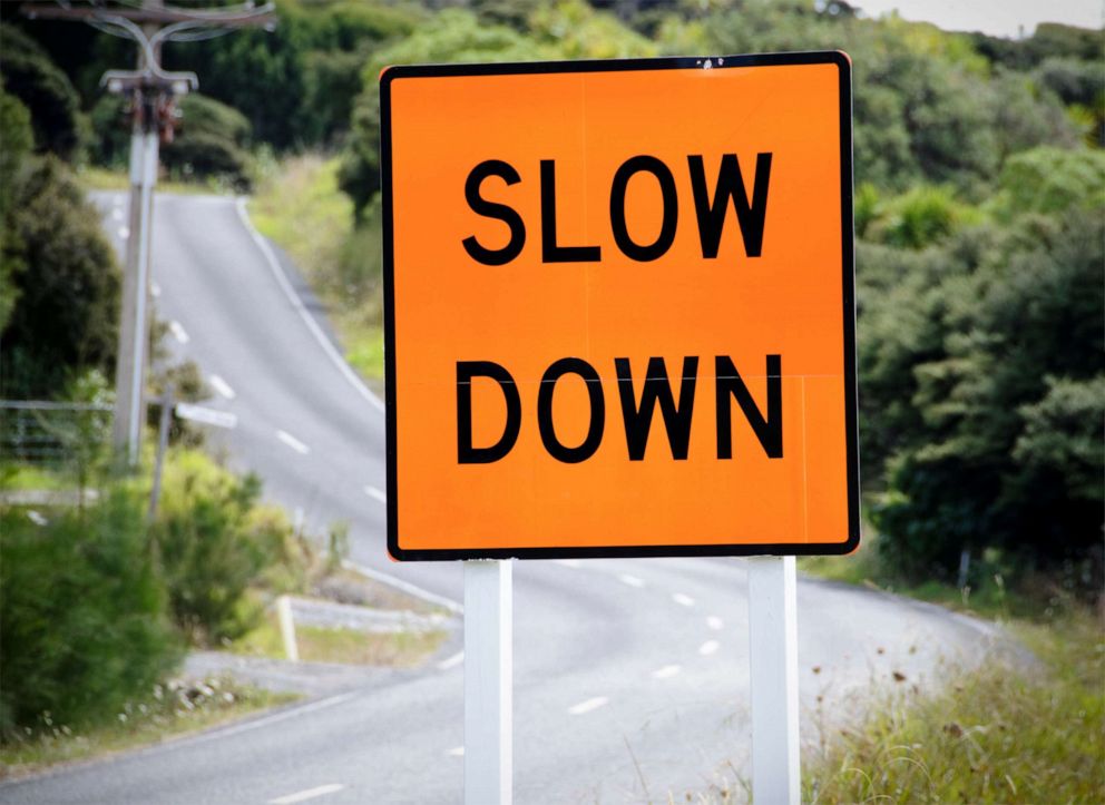 PHOTO: A warning sign advises drives to slow down on a winding rural road in a stock photo.