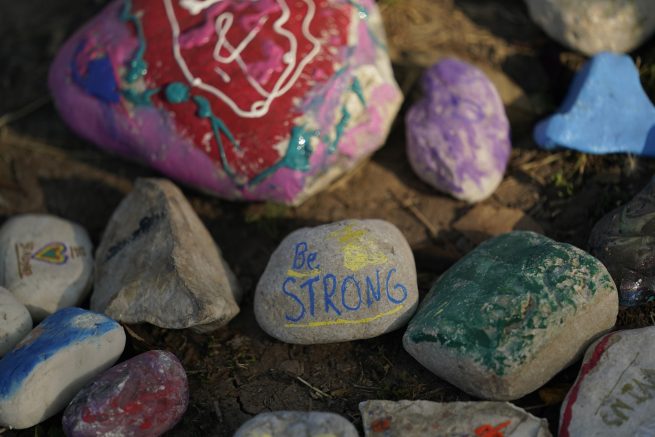 Decorated stones help form a make-shit memorial to honor the victims of the school shootings at Robb Elementary, Tuesday, July 12, 2022, in Uvalde, Texas. In the aftermath of the massacre at Robb Elementary School in Uvalde, Texas, families of victims and many residents are navigating mixed emotions as they channel their grief and fury into demands for change. (AP Photo/Eric Gay)