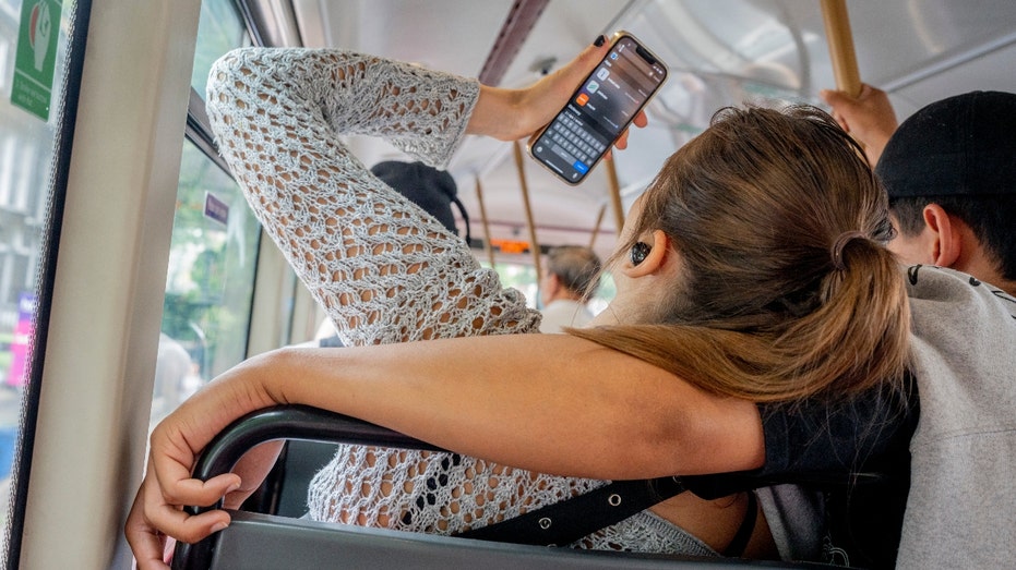 Woman looks at her phone on a bus