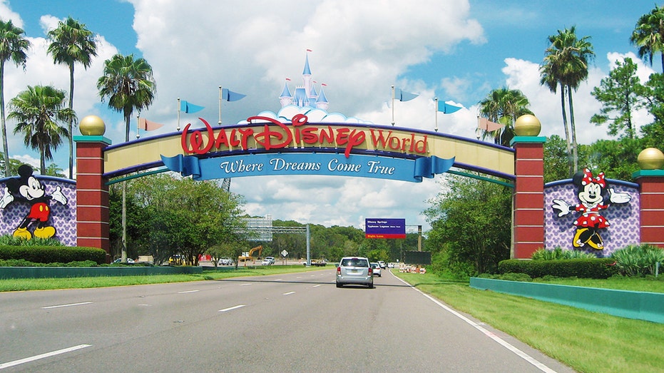 Photo shows car driving through entrance of Walt Disney World in Orlando