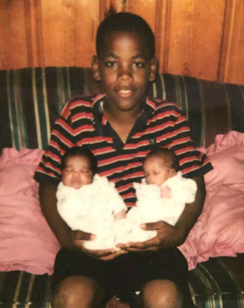 PHOTO: Kastellio Vaughan holds his newborn sisters Kassie and Kascie Vaughan.