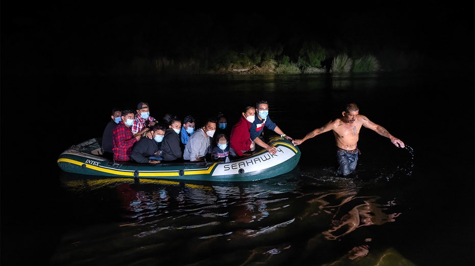 Migrants crossing river