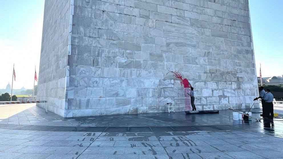 PHOTO: Monument preservation crew members clean red paint off the Washington Monument after it was defaced with red paint, Sept. 20, 2022, in Washington.