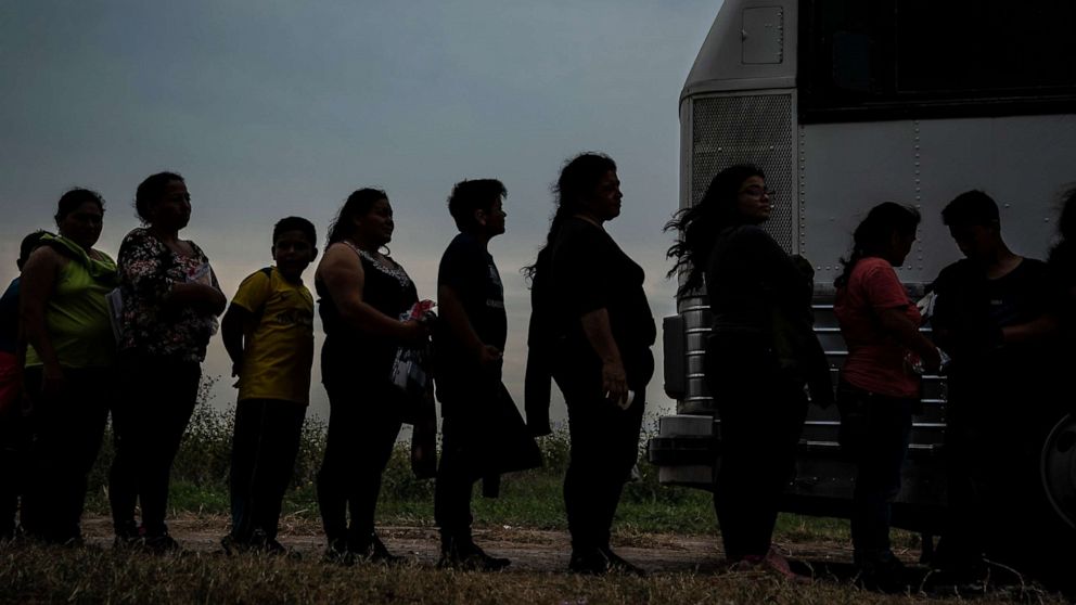 PHOTO: Immigrant families wait to be searched and loaded into transport vans and busses taking them to the U.S. Border Patrol McAllen Station in Los Ebanos, Texas. May 29, 2022.