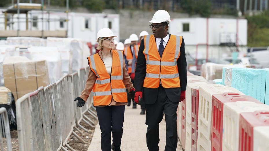 Liz Truss and Kwasi Kwarteng walk through a construction site