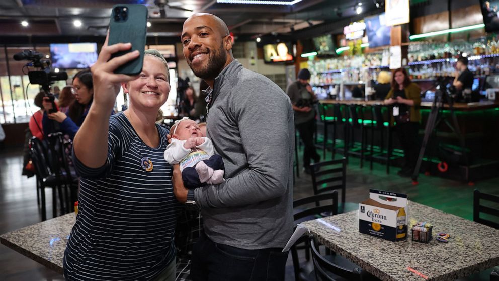 PHOTO: Democratic candidate for U.S. senate in Wisconsin Mandela Barnes poses for a picture with Mandi Miller and her 3-week-old daughter Lark during a campaign stop in West Allis, Wisc., Oct. 12, 2022.