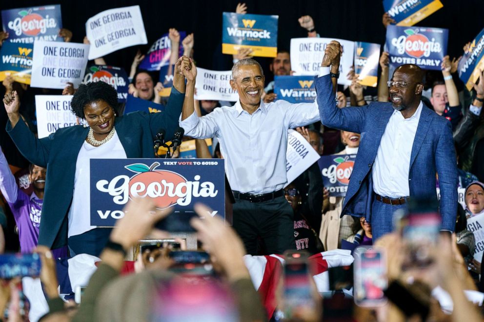 PHOTO: Former President Barack Obama raises hands with Democratic Gubernatorial candidate Stacey Abrams and Sen. Raphael Warnock at a campaign event for Georgia Democrats on Oct. 28, 2022 in College Park, Ga.