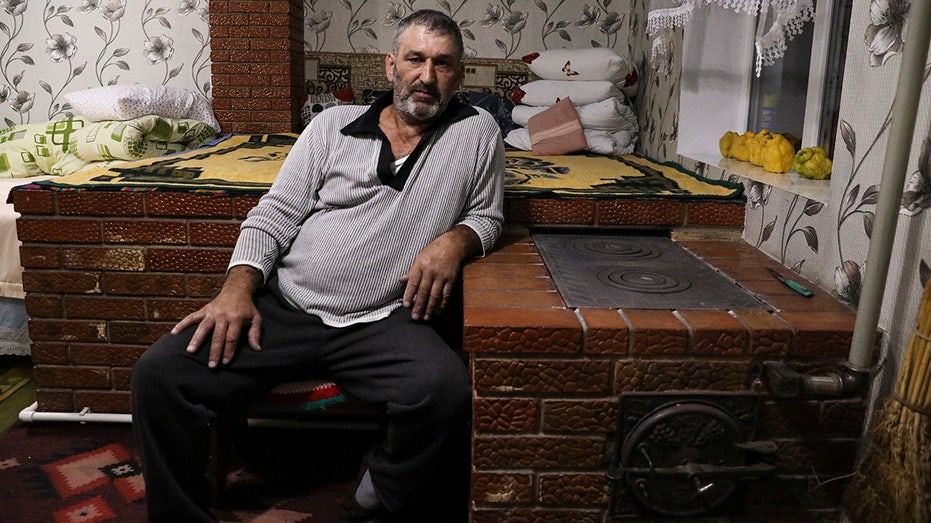 Man leans on wood stove